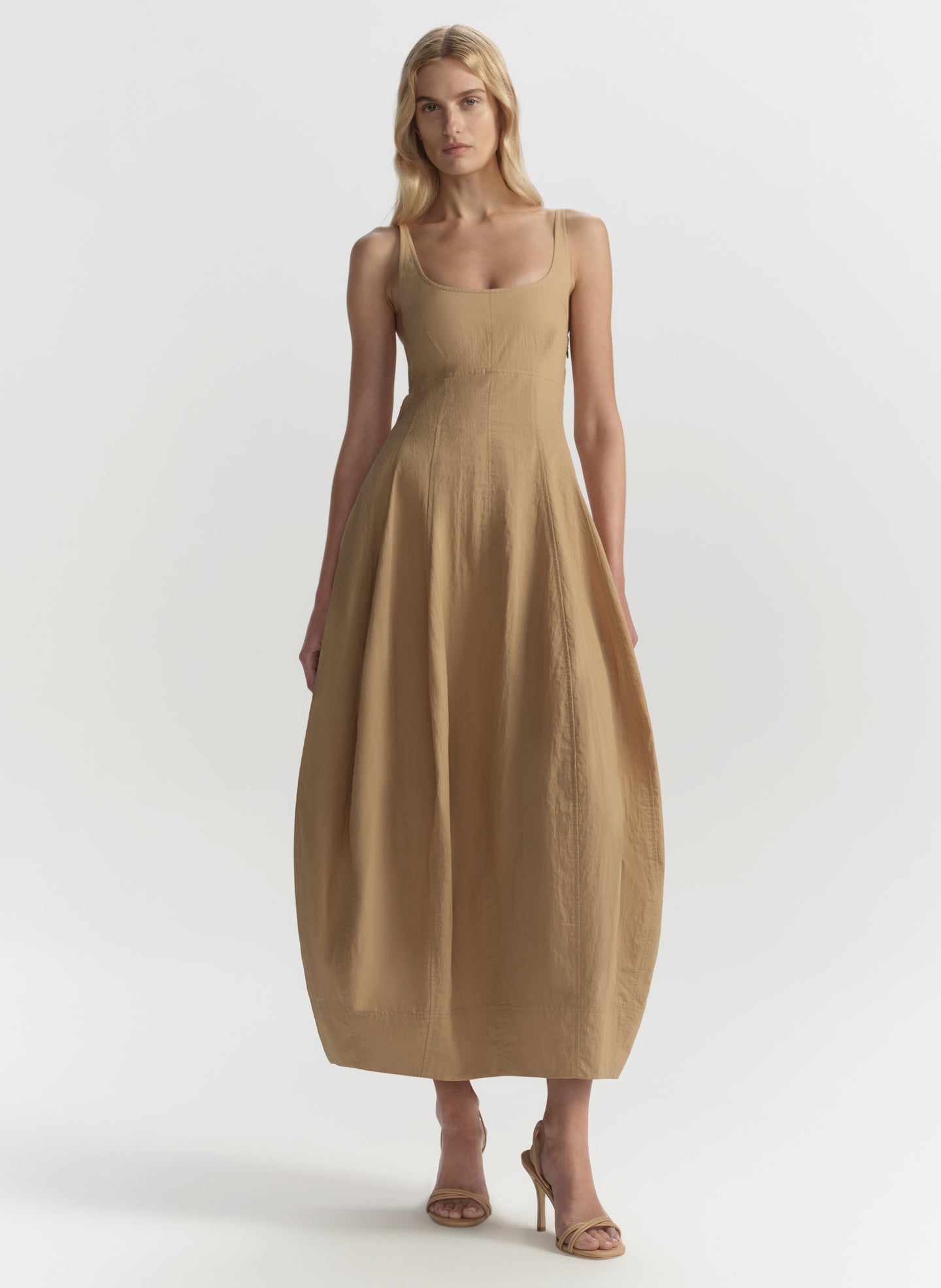 Woman wearing a beige dress on a white background