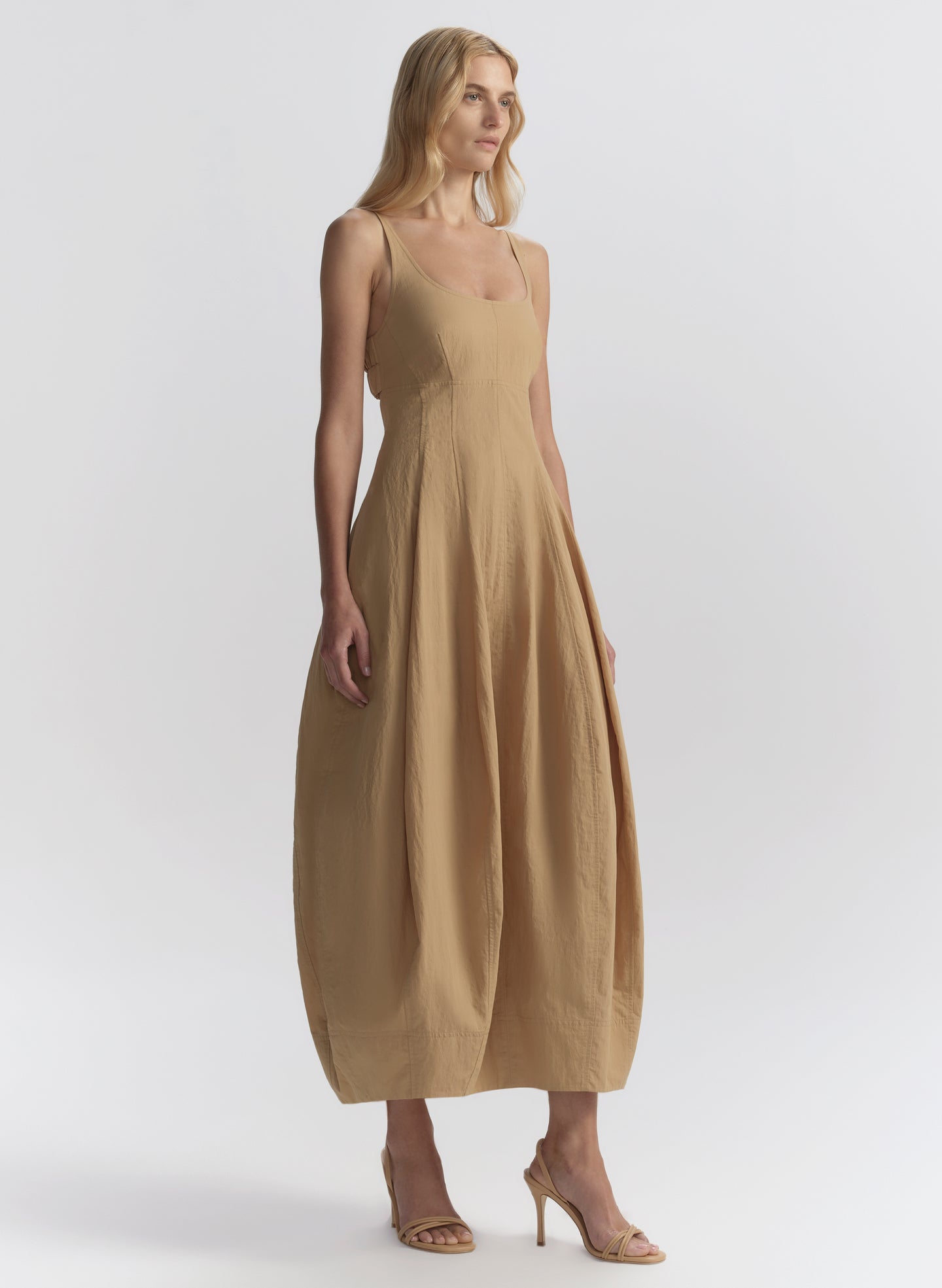 Woman wearing a beige dress on a white background