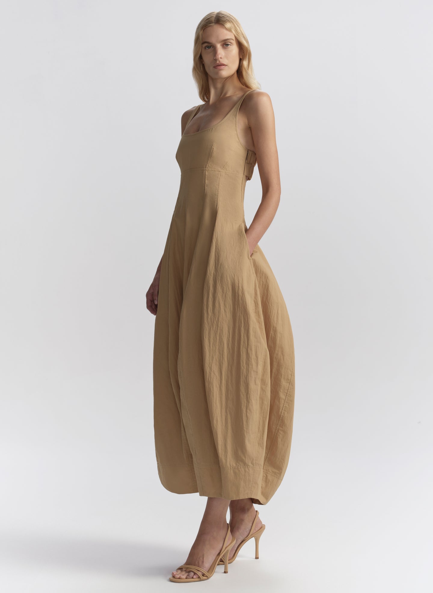 Woman wearing a beige dress on a white background