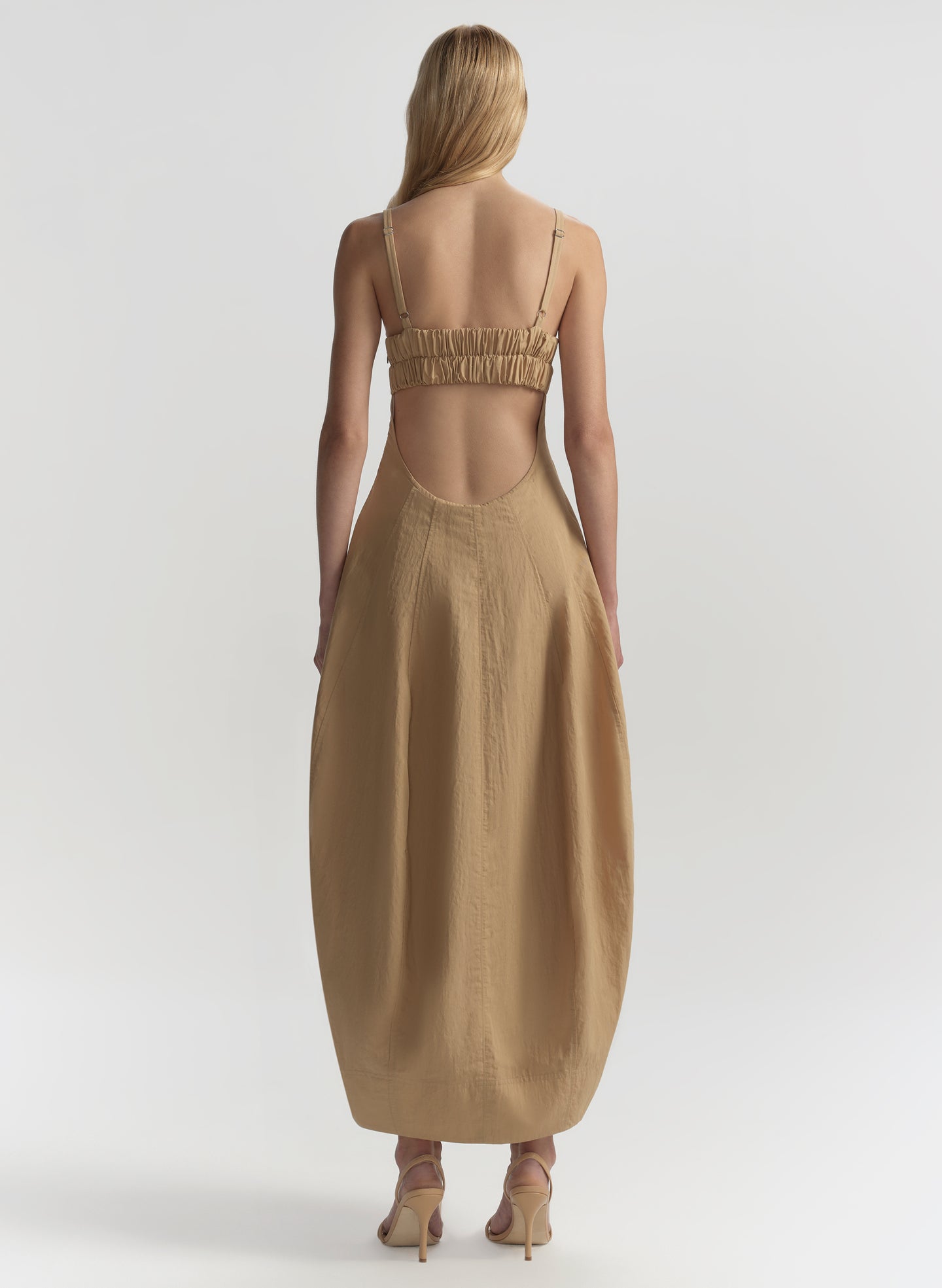 Woman wearing a beige dress with a white background