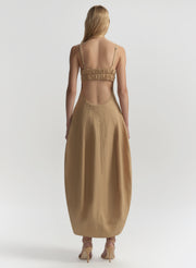 Woman wearing a beige dress with a white background