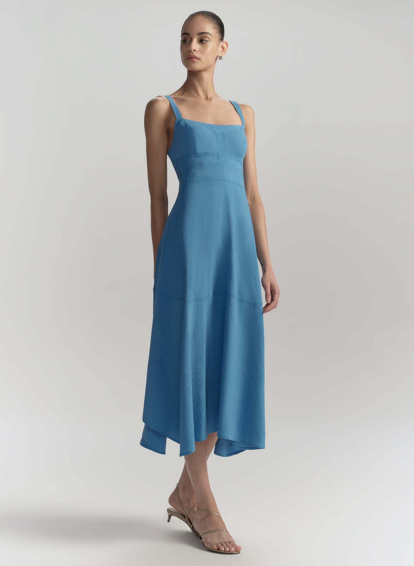 Woman wearing a blue dress against a plain background