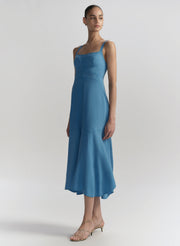 Woman wearing a blue dress against a plain background