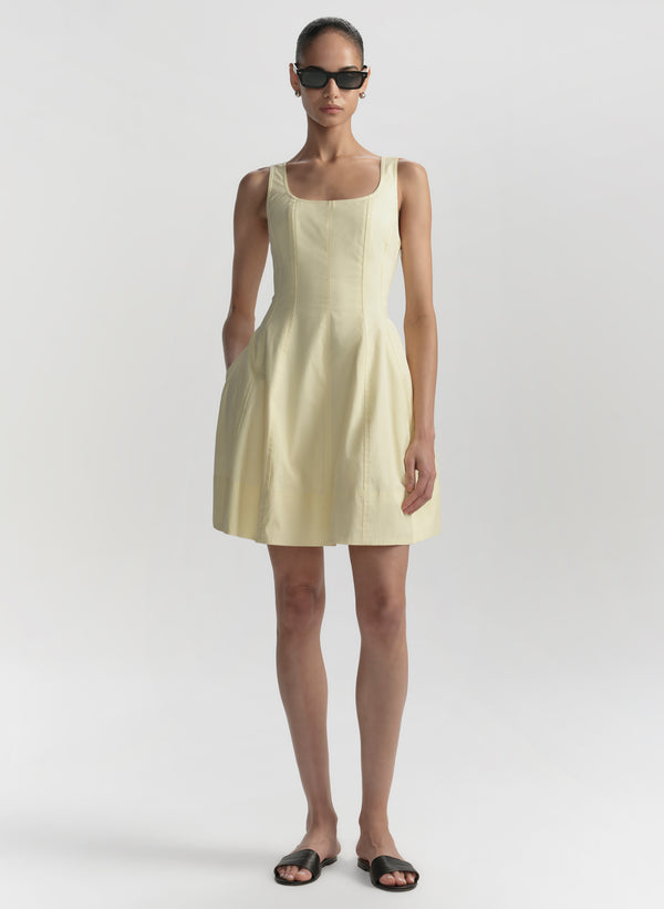 Woman wearing a light yellow dress on a white background