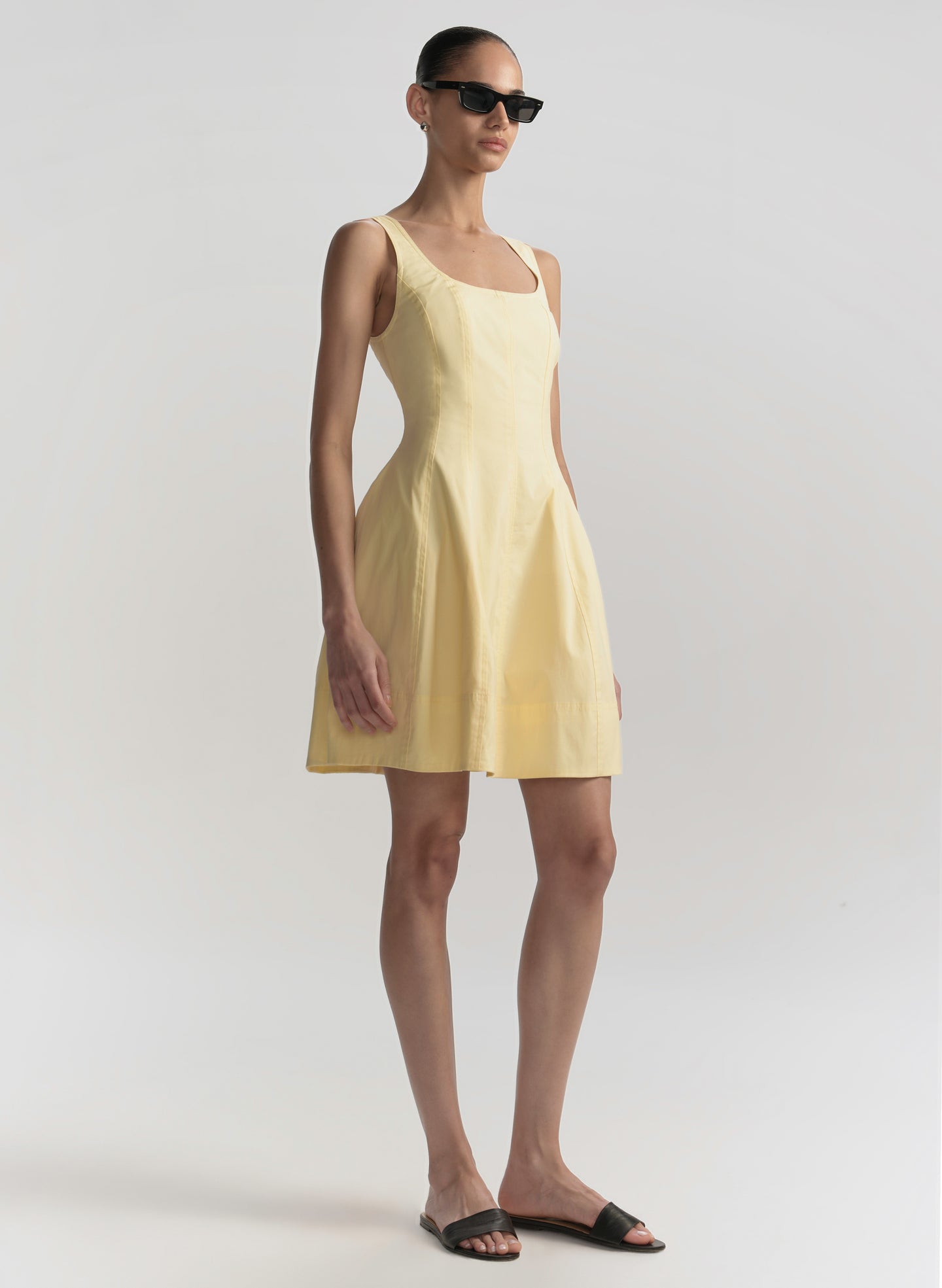 Woman wearing a yellow dress on a plain background