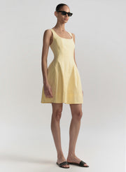 Woman wearing a yellow dress on a plain background