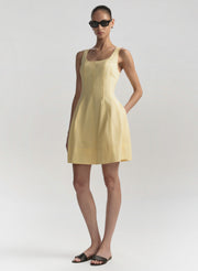 Woman wearing a yellow dress on a plain background