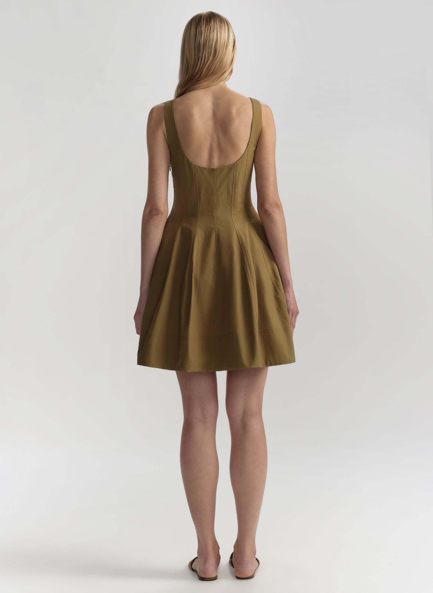 Woman wearing a brown dress with a plain background