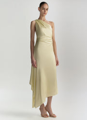 Woman wearing a light yellow one-shoulder dress on a white background