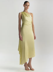 Woman wearing a light yellow one-shoulder dress on a white background