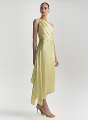 Woman wearing a light yellow one-shoulder dress on a white background