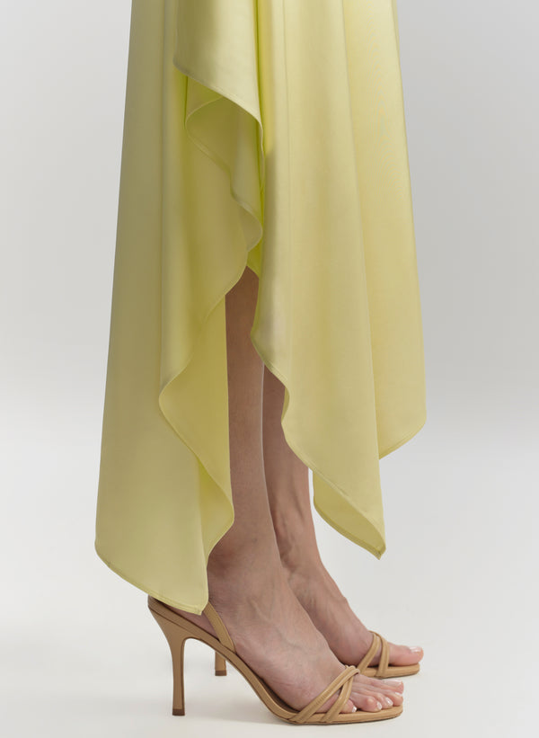Yellow dress with high-low hem and beige high-heeled sandals on a white background