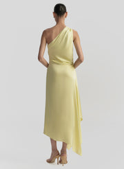 Woman wearing a yellow one-shoulder dress on a light gray background