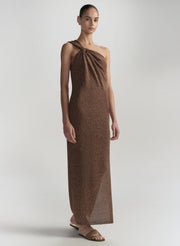 Woman wearing a brown halter neck dress on a plain background