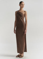 Woman wearing a brown one-shoulder dress on a light gray background