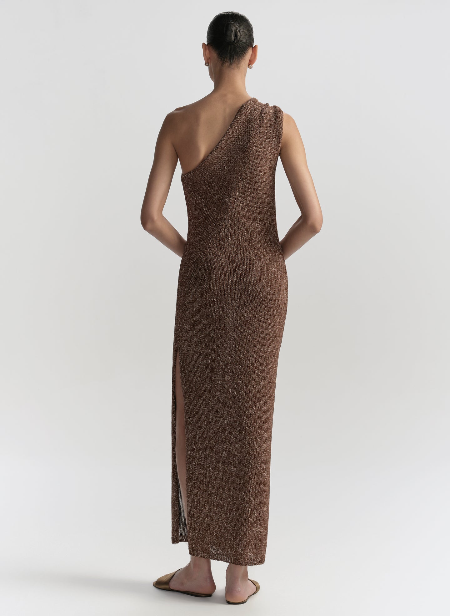 Woman wearing a brown one-shoulder dress on a white background