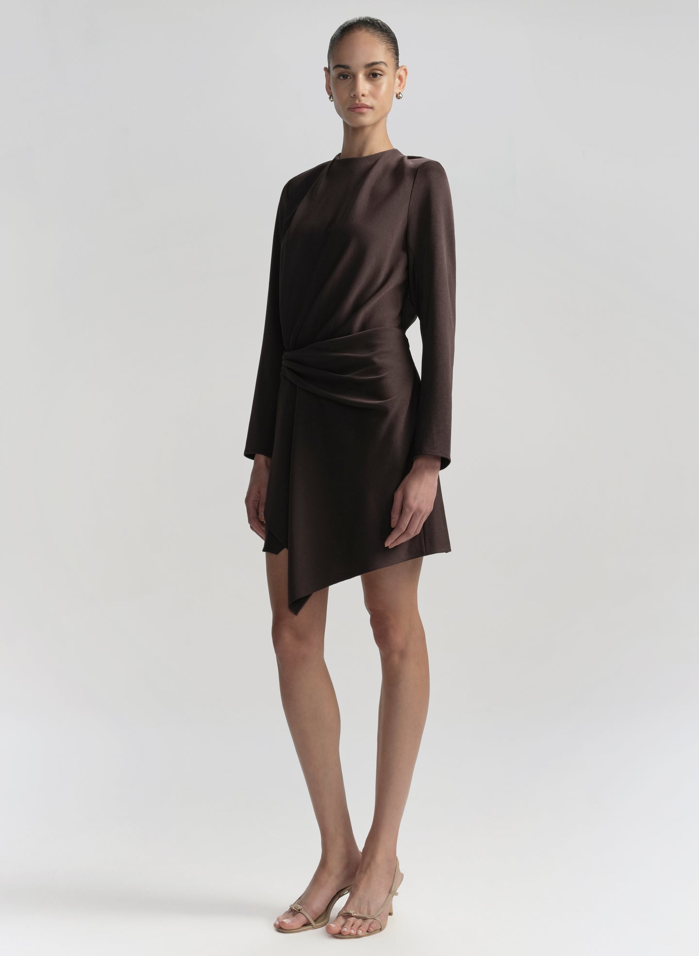 Woman wearing a brown dress on a plain background