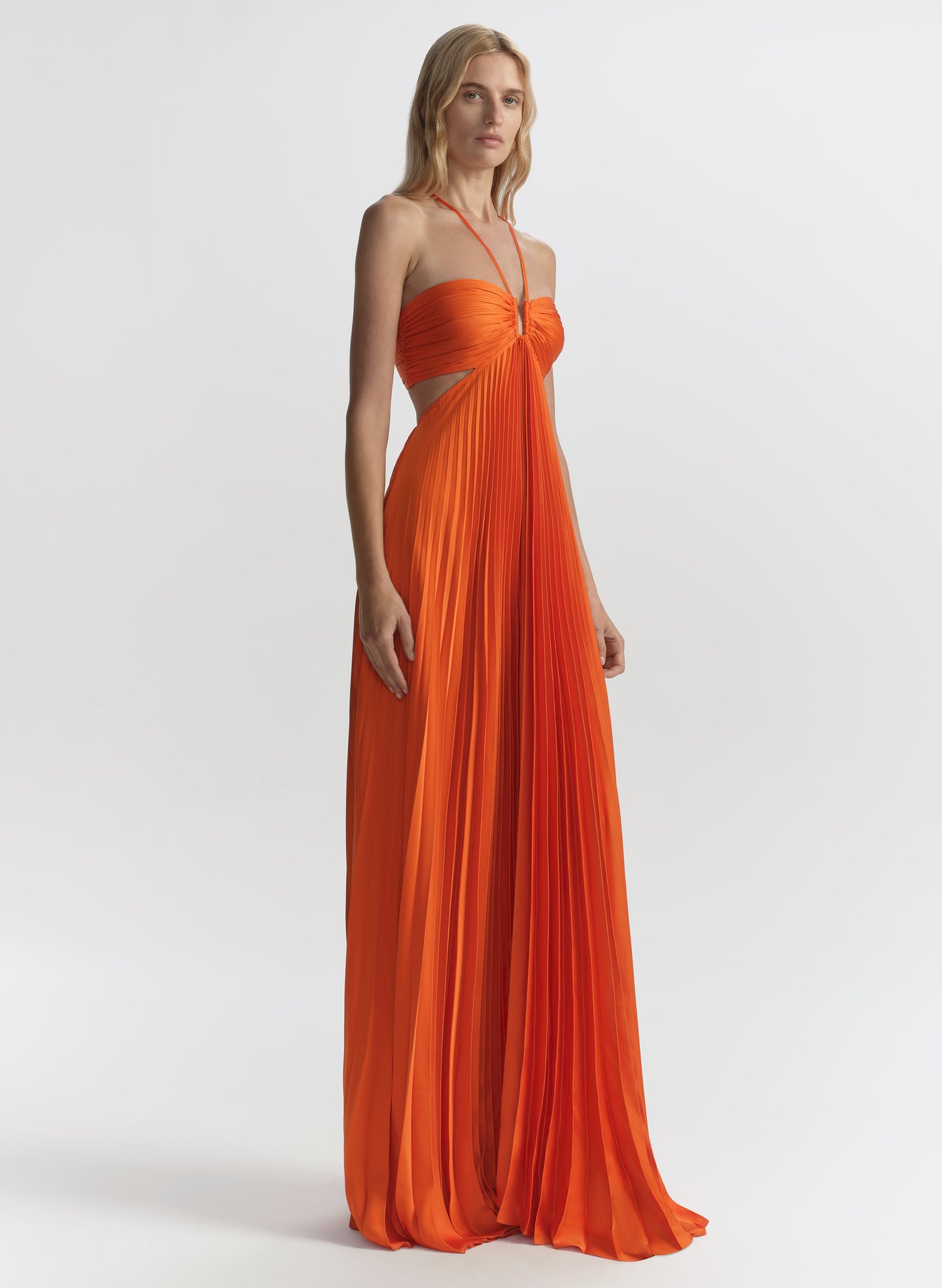 woman wearing orange pleated maxi dress