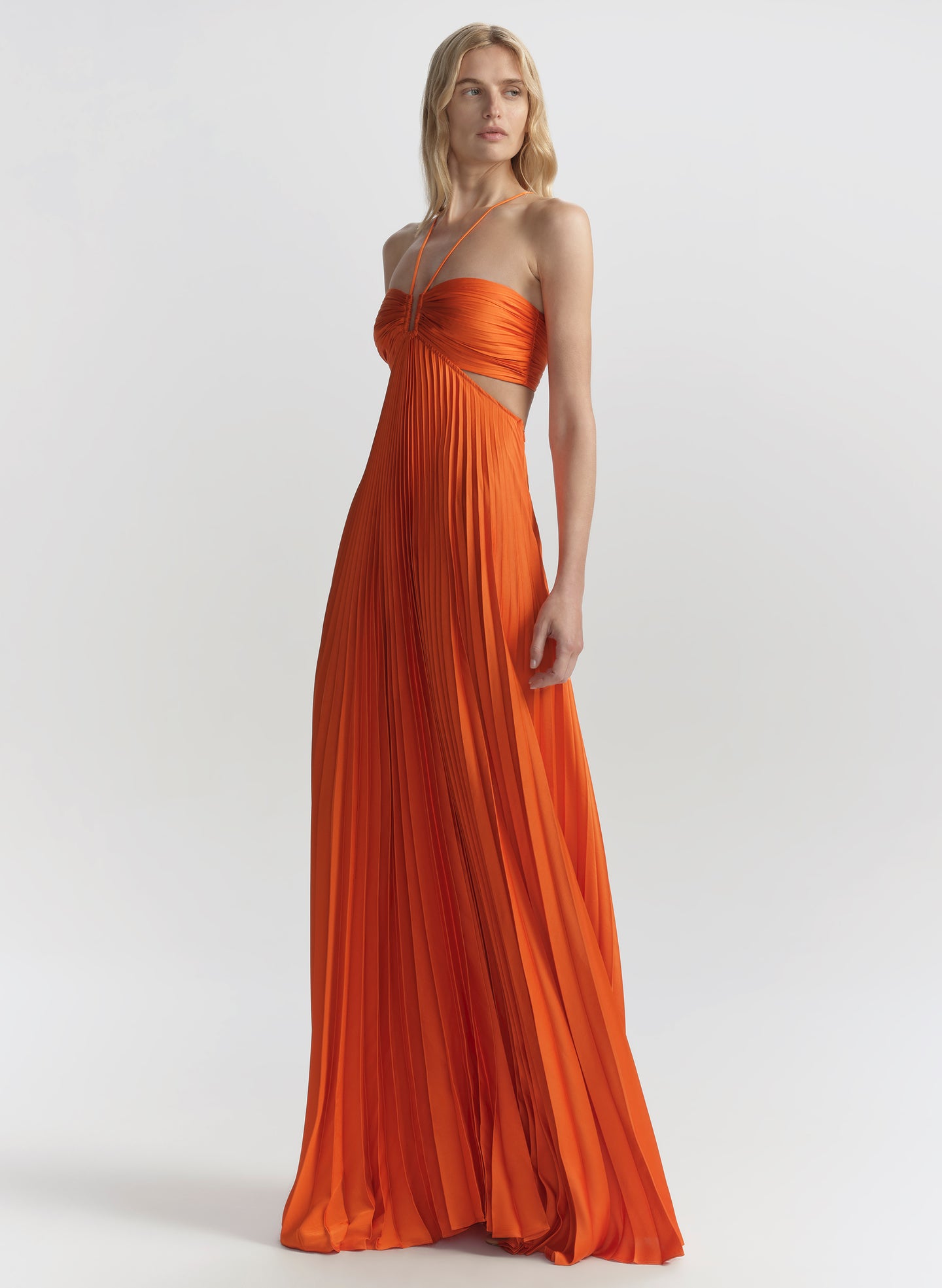 woman wearing orange pleated maxi dress