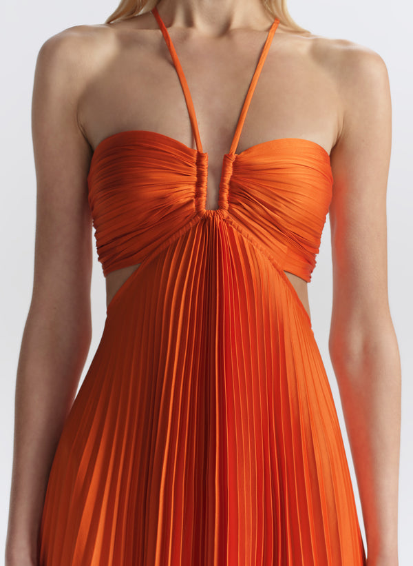 woman wearing orange pleated maxi dress
