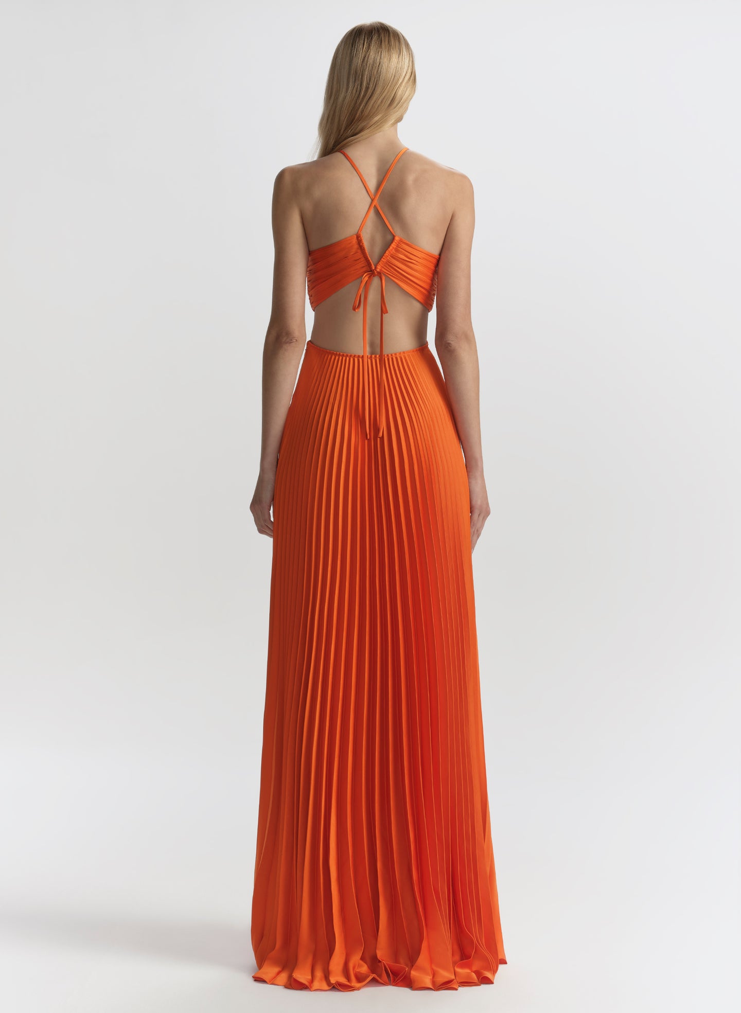 woman wearing orange pleated maxi dress
