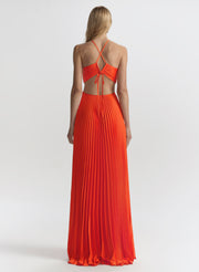Woman wearing a long orange dress with thin straps on a white background