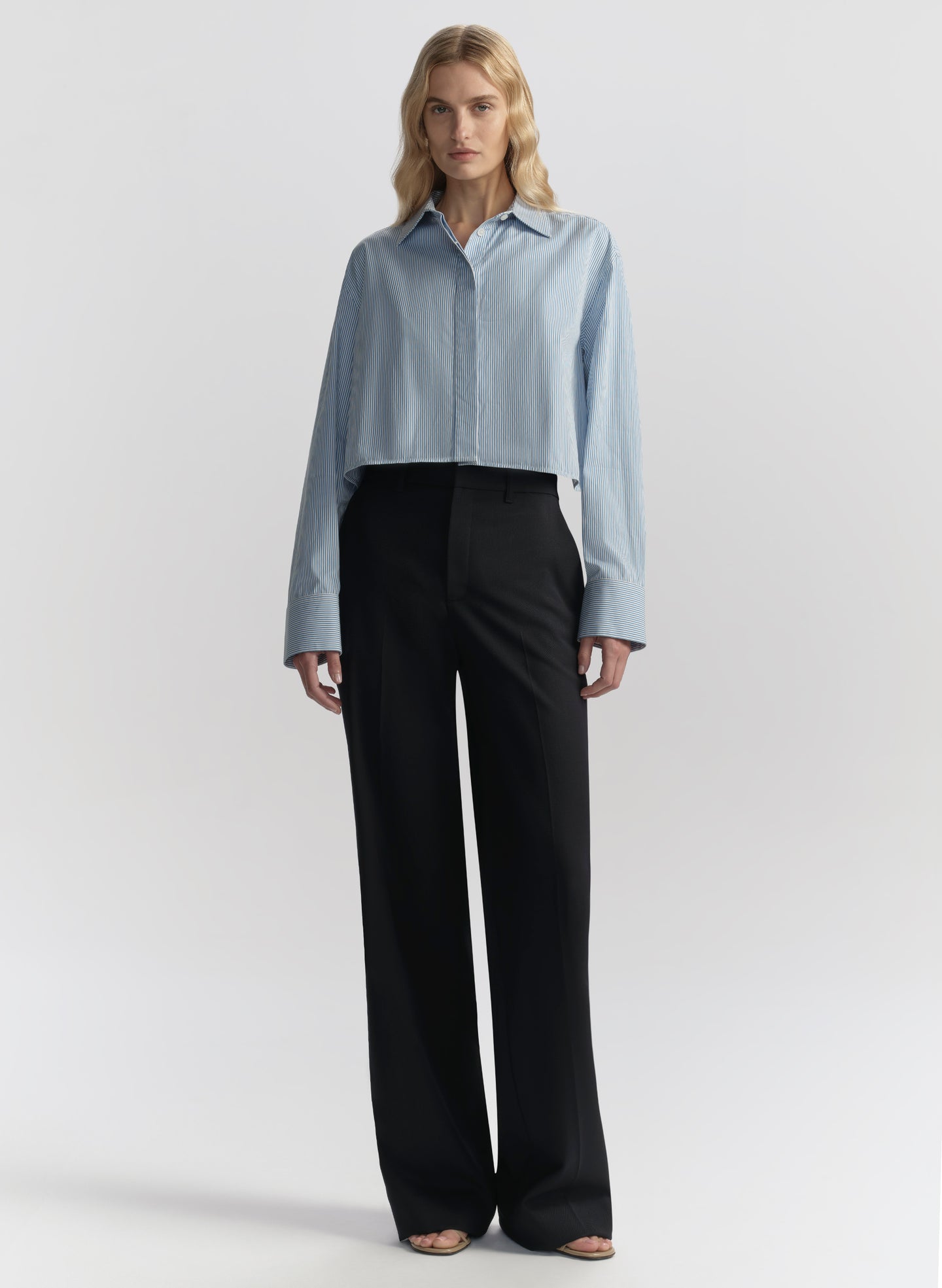 woman wearing light blue striped shirt and navy blue pants