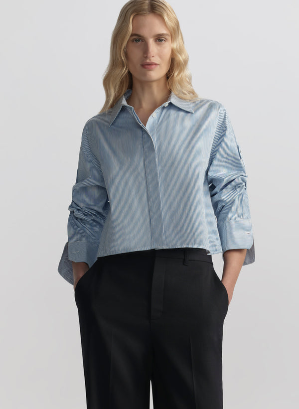 woman wearing light blue striped shirt and navy blue pants