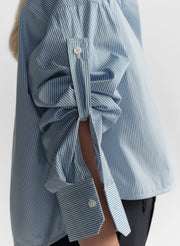 woman wearing light blue striped shirt and navy blue pants