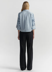 woman wearing light blue striped shirt and navy blue pants