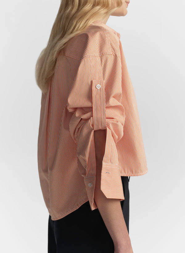 woman wearing orange striped shirt and navy blue pants