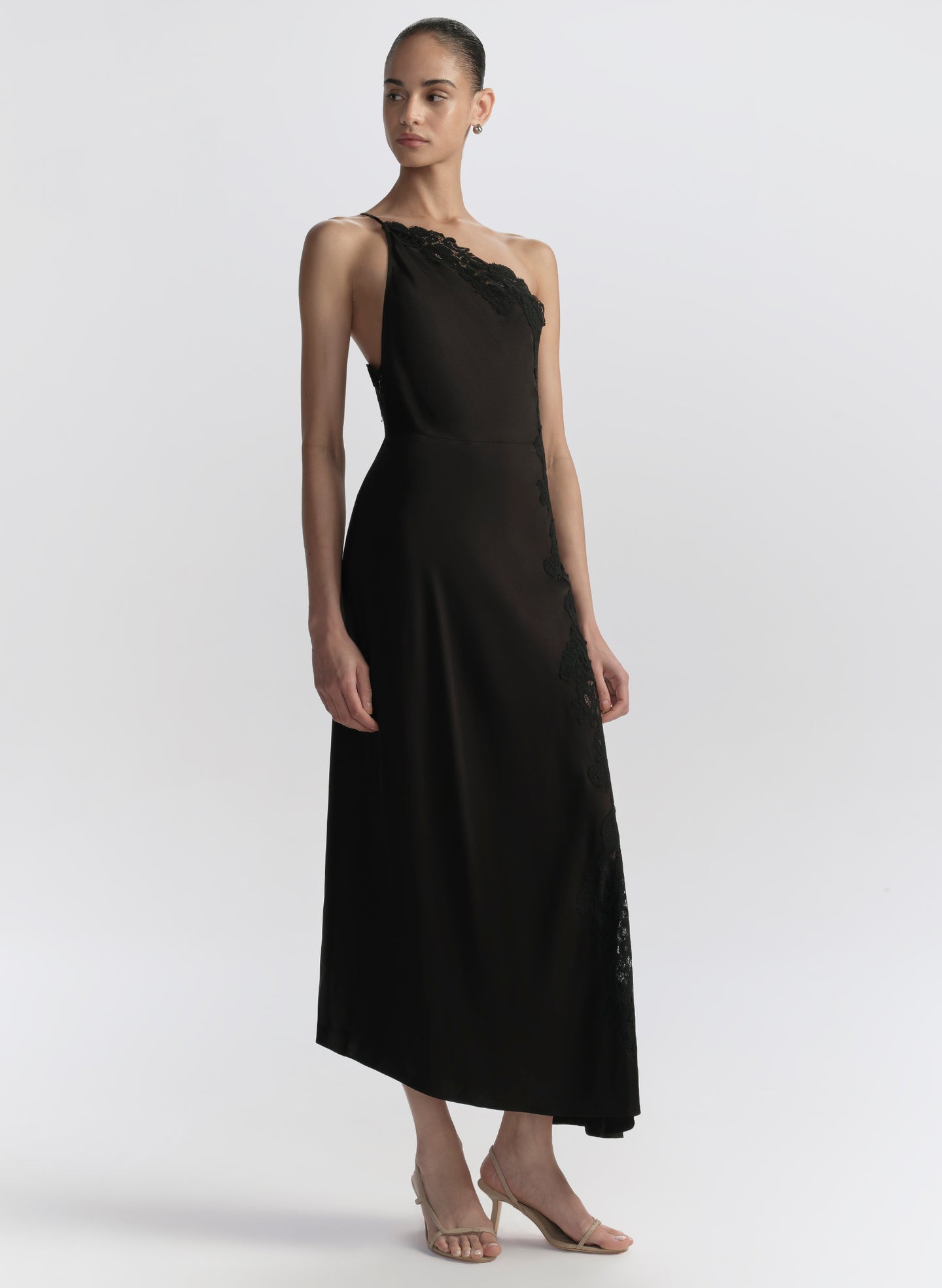 Woman wearing a black one-shoulder dress on a white background