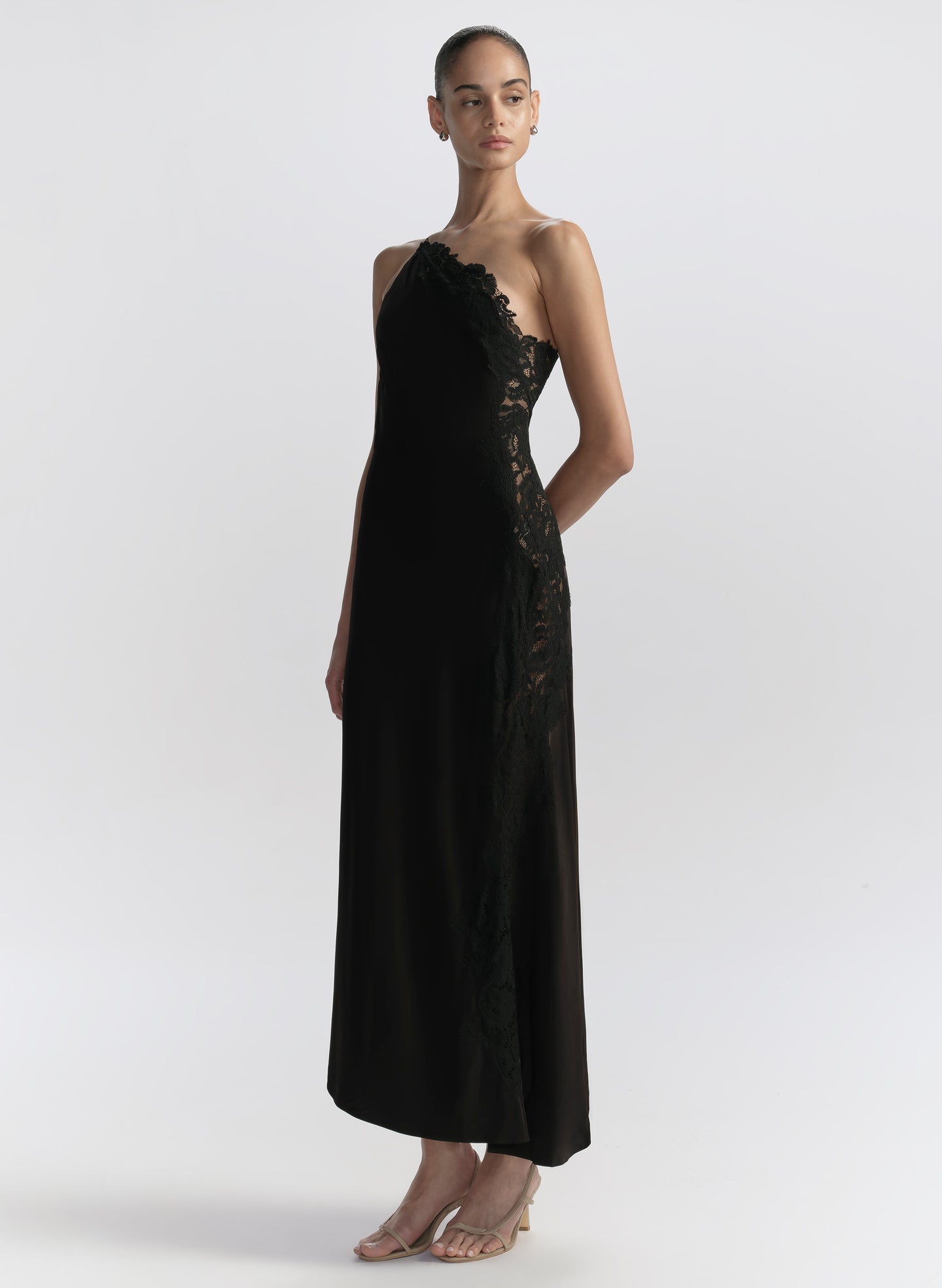 Woman wearing a black one-shoulder dress on a white background