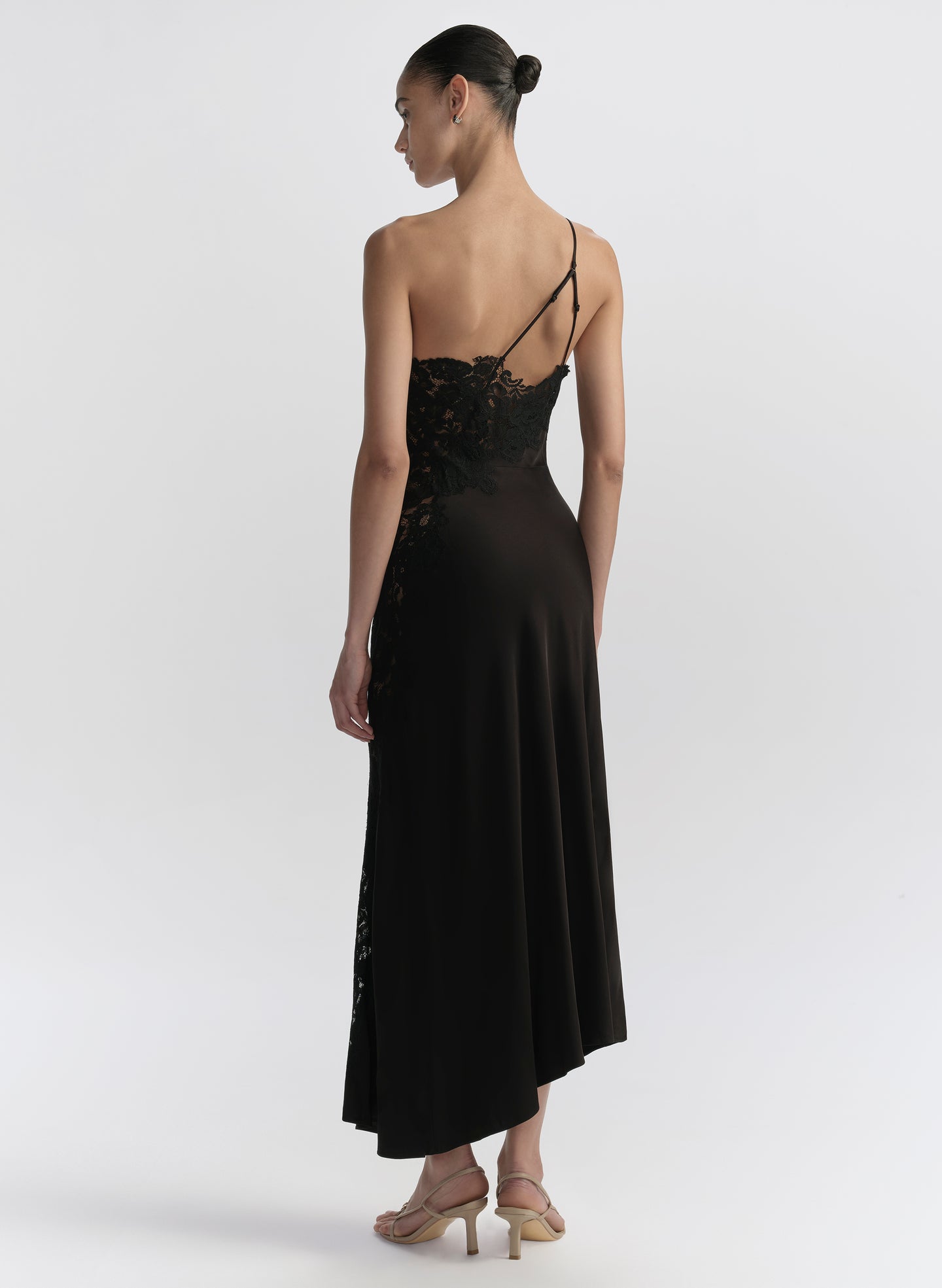 Woman wearing a black one-shoulder dress on a white background