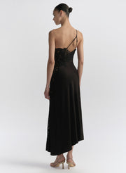 Woman wearing a black one-shoulder dress on a white background