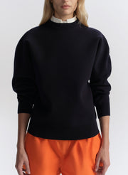 woman wearing navy blue sweater and orange shorts