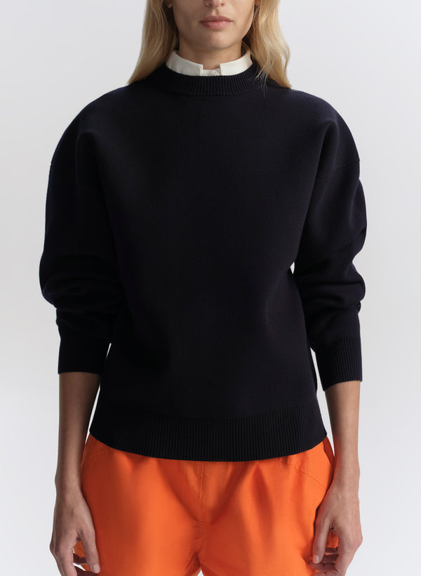 woman wearing navy blue sweater and orange shorts