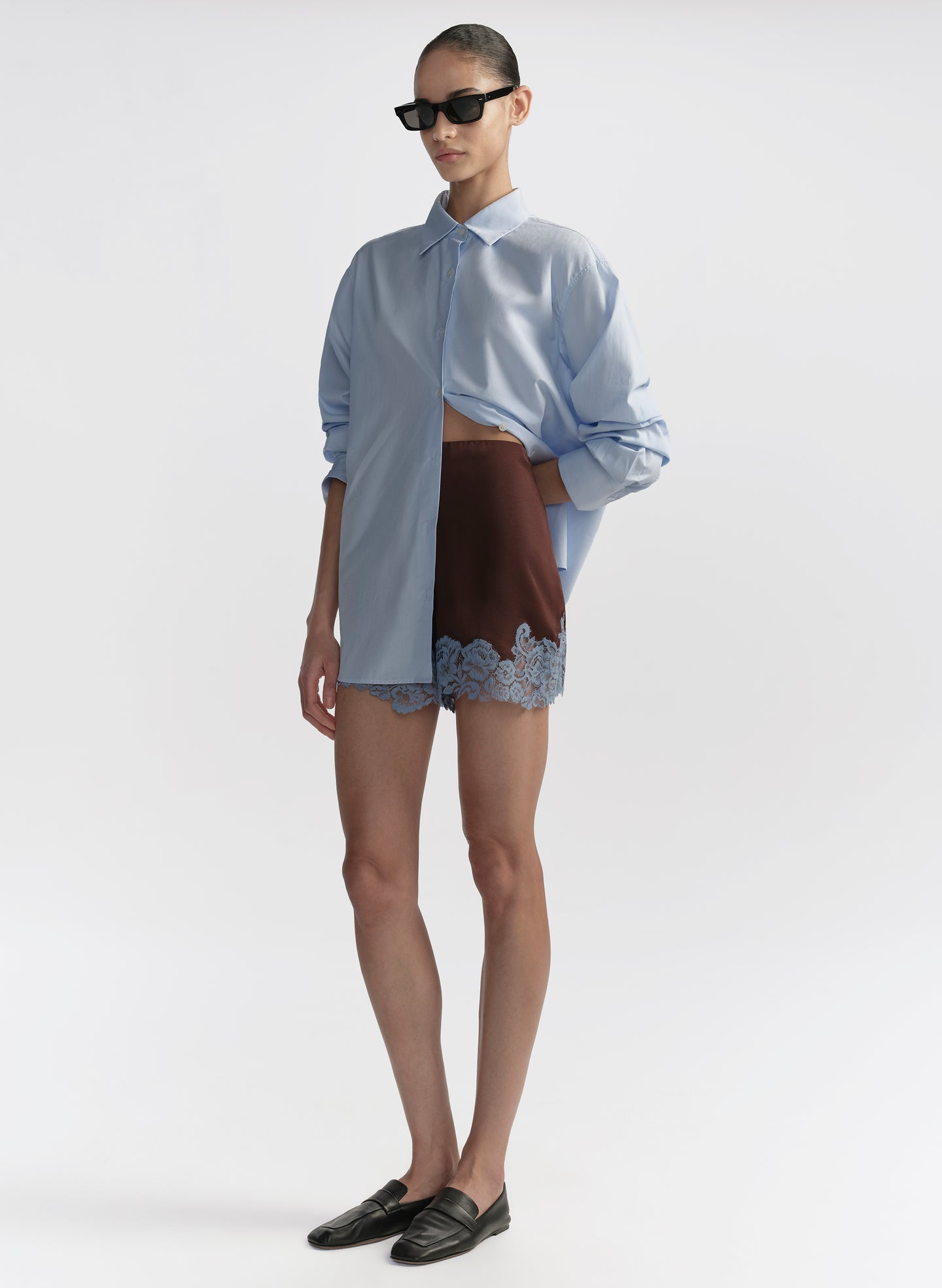woman wearing light blue shirt and brown shorts