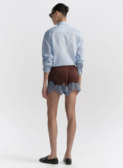 woman wearing light blue shirt and brown shorts