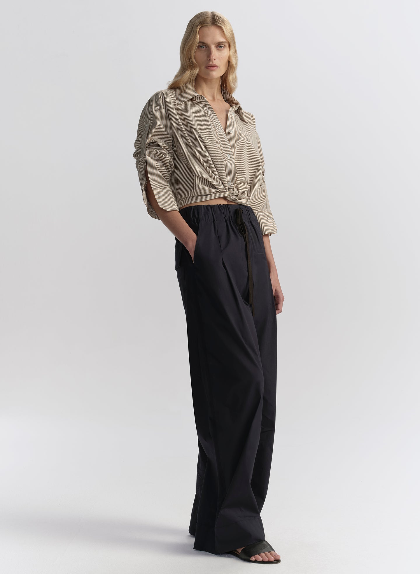 woman wearing brown striped shirt and navy blue pants