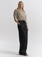 woman wearing brown striped shirt and navy blue pants