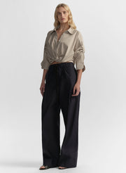 woman wearing brown striped shirt and navy blue pants