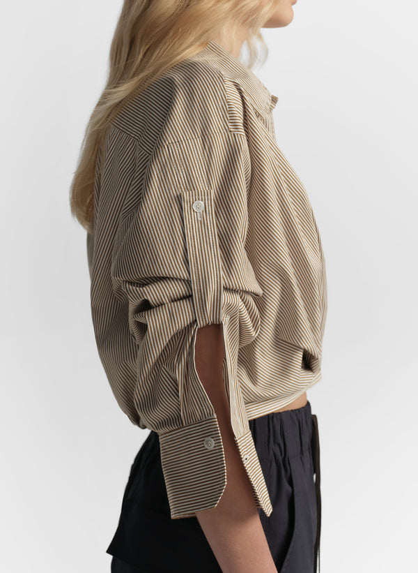 woman wearing brown striped shirt and navy blue pants