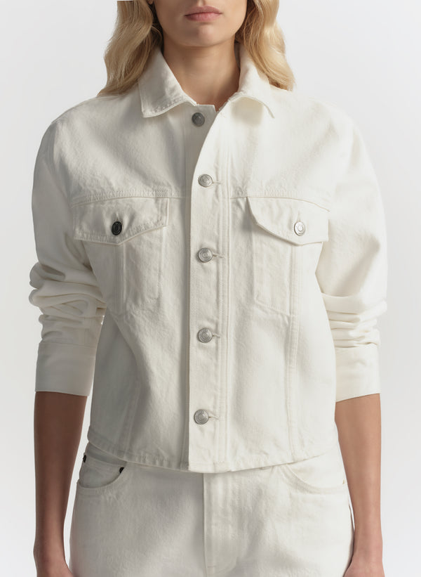 White denim jacket worn by a person on a white background
