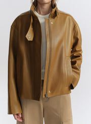 Brown leather jacket worn by a person on a white background