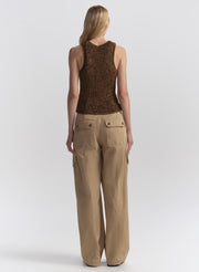 Woman wearing a brown sleeveless top and beige cargo pants on a white background