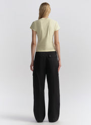 Person wearing a light yellow t-shirt and blue pants on a white background