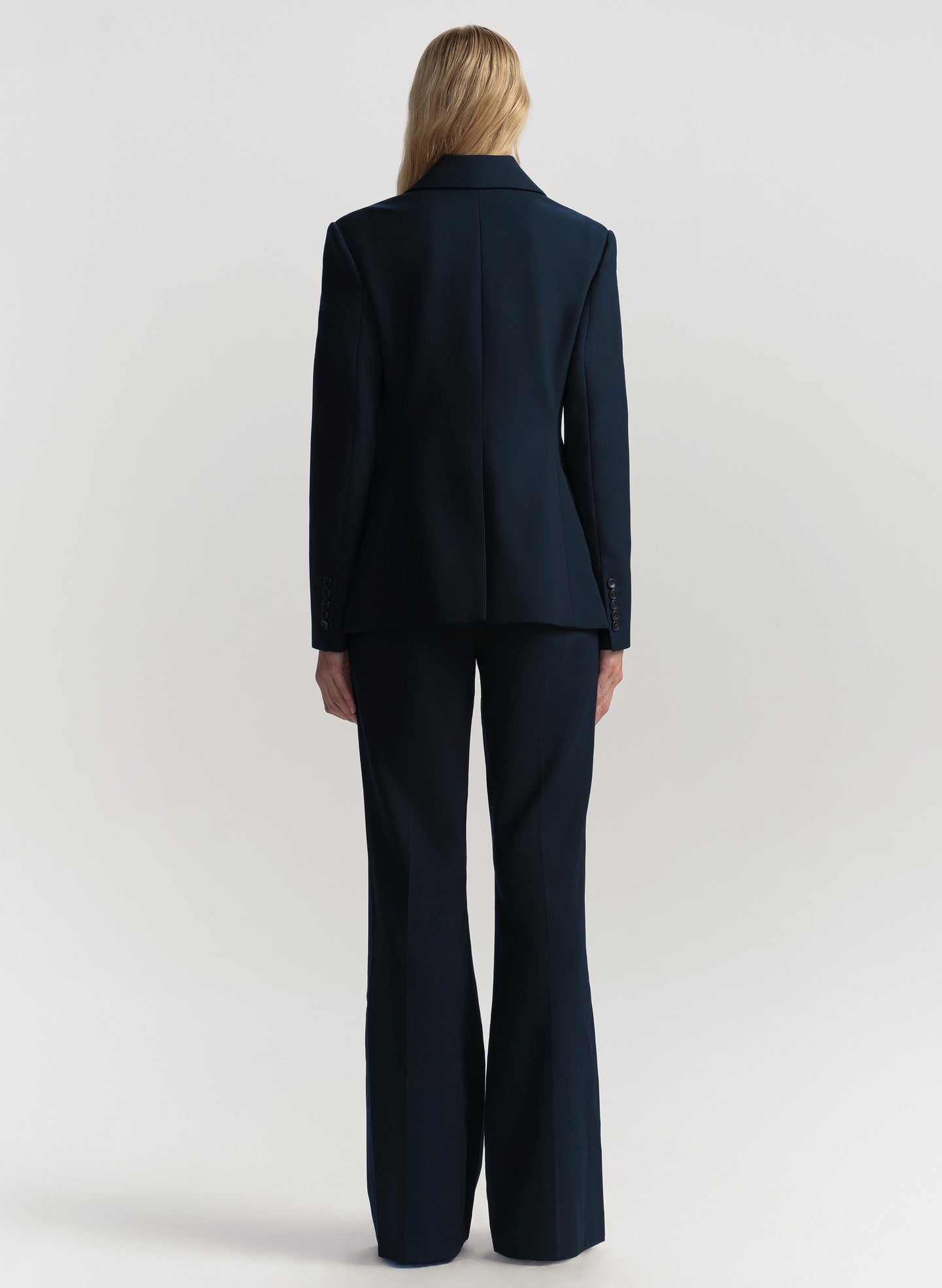 Person wearing a navy suit on a white background