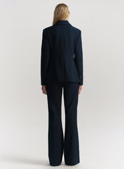 Person wearing a navy suit on a white background