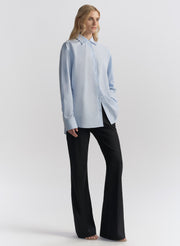 woman wearing light blue shirt and black pants